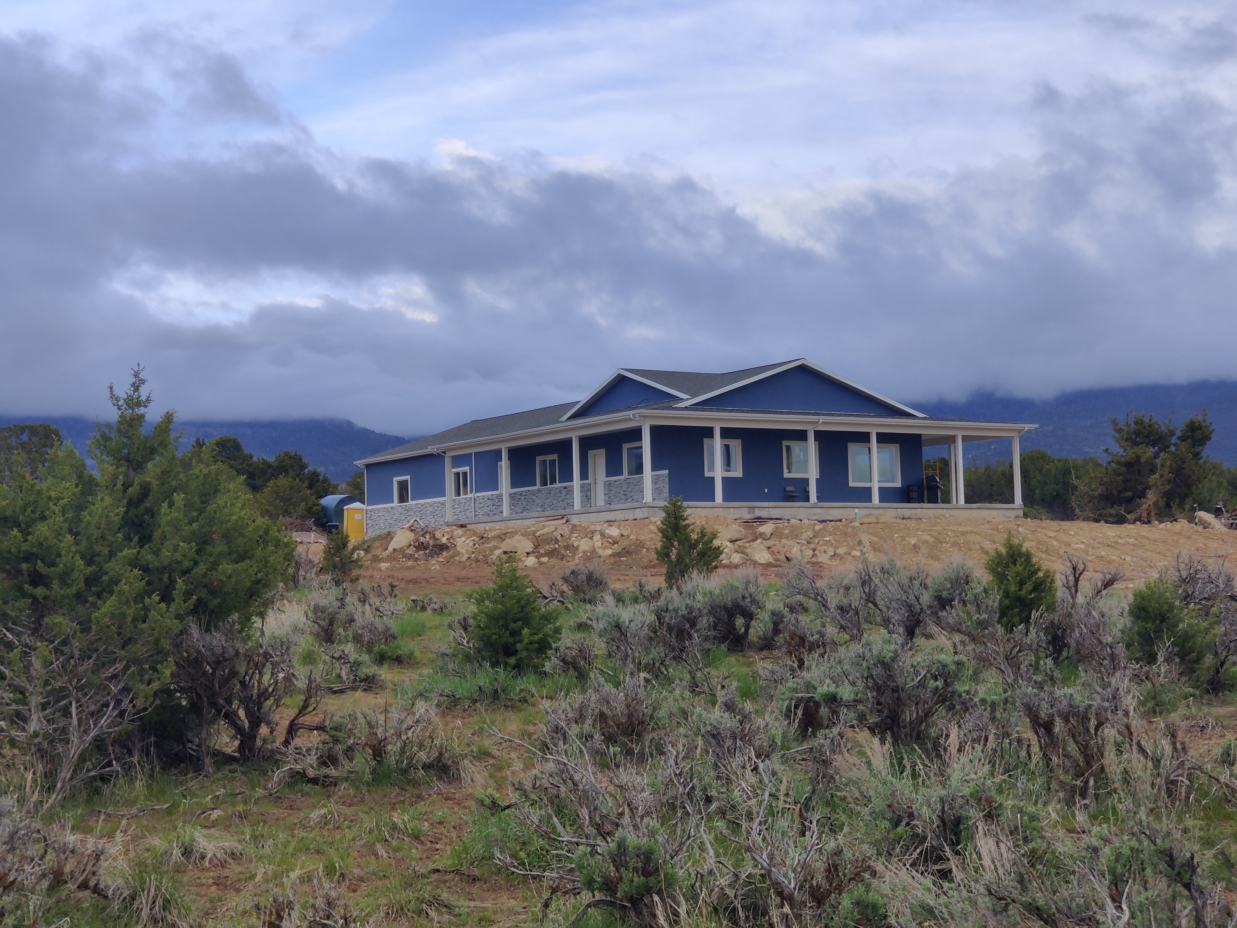 The Rencher residence on property in Spring City, Utah — juniper-covered land with a view of the Sanpete Valley